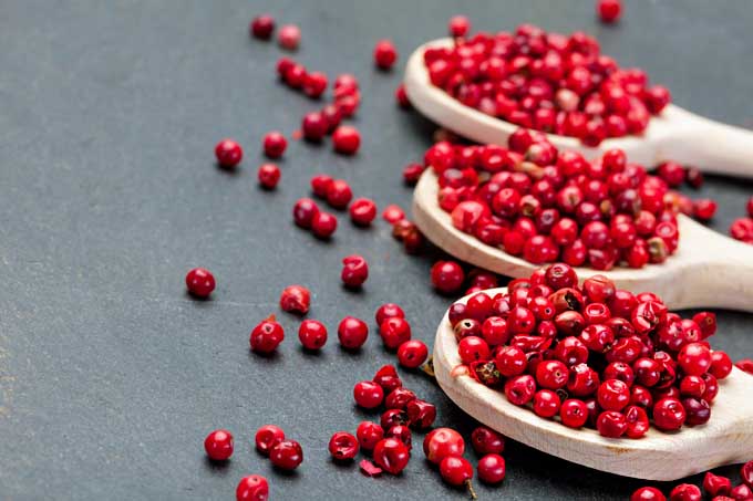 Fresh pink peppercorns in three woodens spoons 